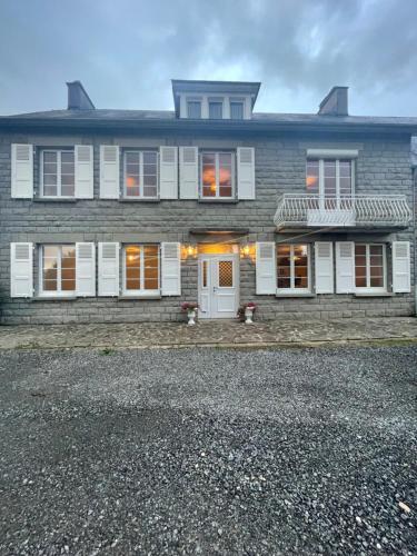 a large brick house with white doors and windows at LA BUTTE - Maison de vacances Avranches avec vue sur le Mont Saint Michel in Le Val-Saint-Père