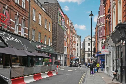 eine Stadtstraße mit Gebäuden und Menschen, die die Straße hinuntergehen in der Unterkunft Soho Apartment, Piccadilly & Regent Street in London