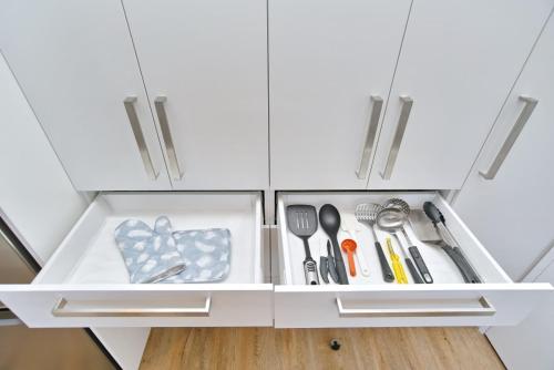 a drawer in a kitchen cabinet filled with utensils at Lavandula 4 - Christchurch Holiday Homes in Christchurch