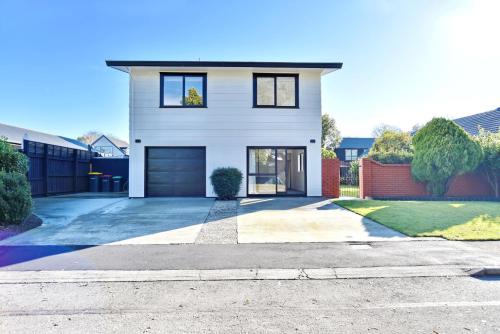a white house with a driveway at Lavandula 4 - Christchurch Holiday Homes in Christchurch