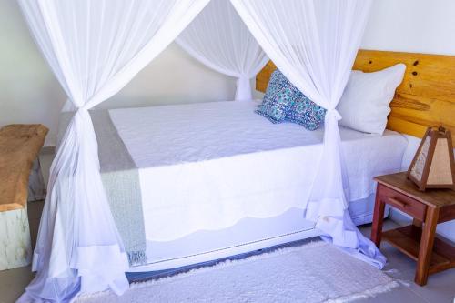 a bedroom with a bed with white drapes at Pousada Rio da Vila in Porto Seguro