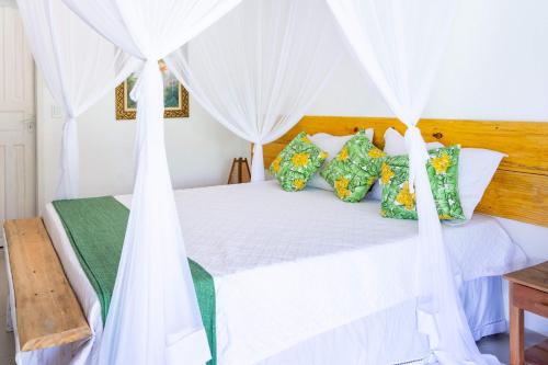 a bedroom with a bed with white drapes at Pousada Rio da Vila in Porto Seguro