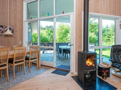 Fjand Gårdeにある8 person holiday home in Ulfborgの暖炉付きのリビングルーム(テーブル、椅子付)