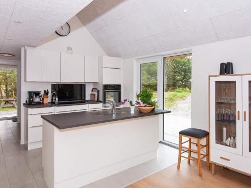 een keuken met witte kasten en een zwart aanrecht bij 6 person holiday home in R m in Toftum
