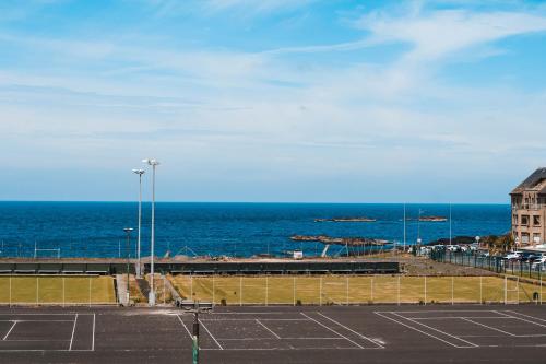 um parque de estacionamento com o oceano ao fundo em Luxury Sea View Apartment em Portrush