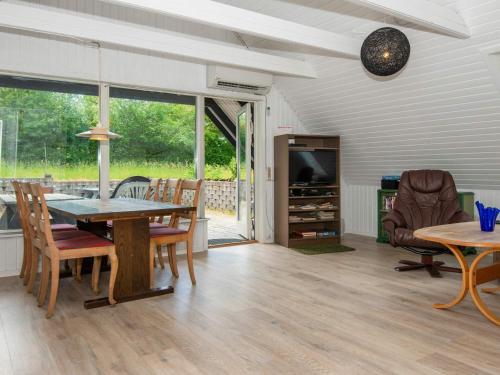 a dining room with a table and chairs and a television at 6 person holiday home in Ebeltoft in Ebeltoft