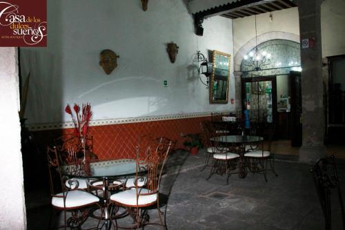 a restaurant with tables and chairs and a bath tub at Casa de los Dulces Sueños in Morelia