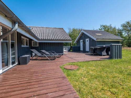 a deck with chairs and a table on a house at Secluded Haven in Rindby in Fanø