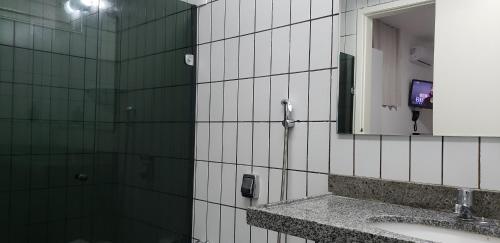 a bathroom with a sink and a mirror at LIVE IN FORTALEZA HOTEL in Fortaleza