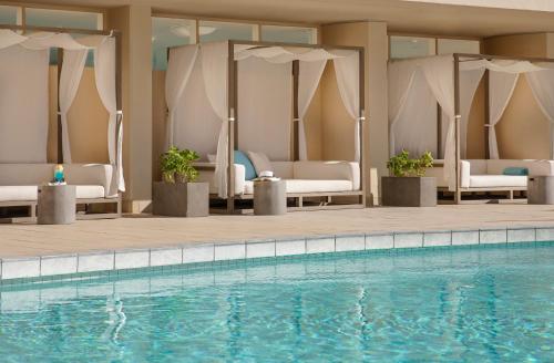 a swimming pool with white chairs and a swimming pool at The Twin Fin Hotel in Honolulu
