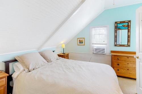 Schlafzimmer mit einem Bett, einer Kommode und einem Spiegel in der Unterkunft Historic Jewel in Provincetown