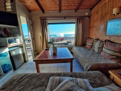 a living room with a couch and a table at El Rincon de Las Pleyades in El Quisco