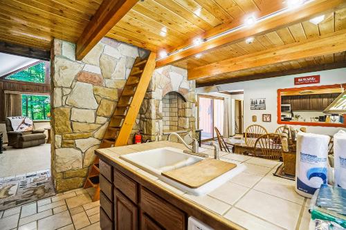 a kitchen with a sink and a stone wall at Ski Tips Up in Thompsonville