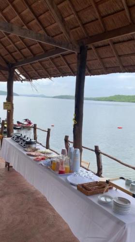 a long table with food on it next to the water at Hotel Fazenda Monte Cristo in Piranhas