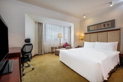 a hotel room with a large white bed and a desk at Holiday Inn Temple Of Heaven Beijing by IHG in Beijing