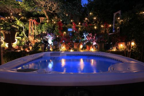 a hot tub in a garden with christmas lights at The Green Ginger Guest House in Los Angeles