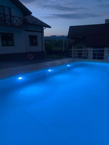 a swimming pool in front of a house at night at Карпатский уикенд in Slavske