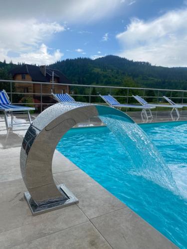a swimming pool with a fountain in the middle at Карпатский уикенд in Slavske