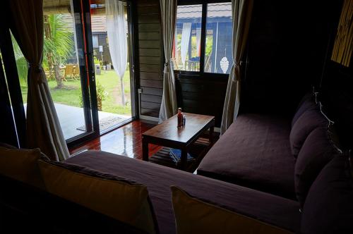 a room with a bed and a table and a window at La Perle Tahaa in Tapu' amu