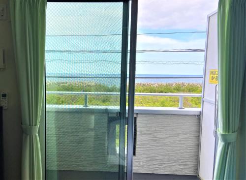 a room with a window with a view of the ocean at Tabist Hotel Takagiya Iwaki in Hisanohama