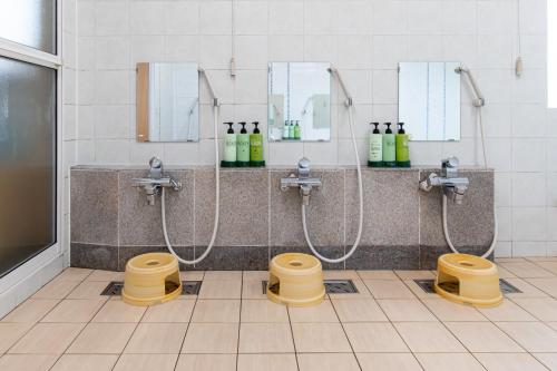 a public bathroom with two sinks and two toilets at Tabist Hotel Takagiya Iwaki in Hisanohama