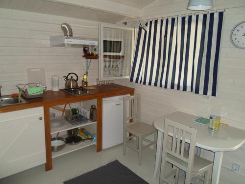 a small kitchen with a table and a table and chairs at Tihase puhkemajake in Pärnu