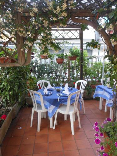 a table and chairs sitting on a patio with flowers at Hotel Fiammetta in Quercianella