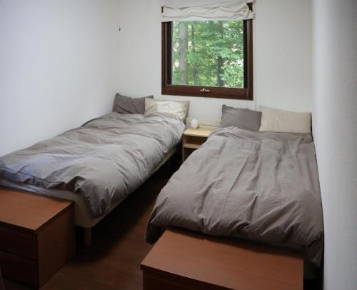 two beds in a room with a window at Guesthouse Coteau - Vacation STAY 5450 in Biei
