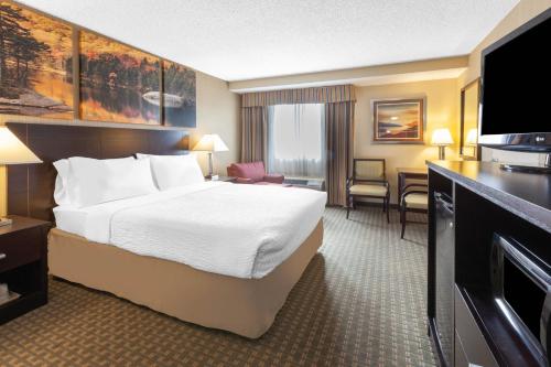 a hotel room with a bed and a desk at Days Inn by Wyndham Plattsburgh in Plattsburgh