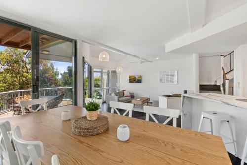 a kitchen and living room with a table and chairs at Castaway Cove Beachfront Home by Stay Noosa in Marcus Beach