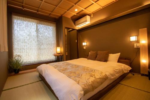 a bedroom with a large bed and a window at Core Base Sumiyoshi in Fukuoka