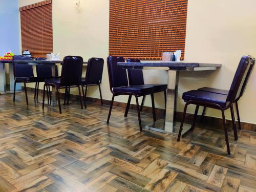 a dining room with blue chairs and wooden floors at THAAI RESIDENCY in Tiruvannāmalai