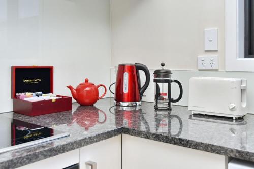 a kitchen counter with a coffee maker and a tea kettle at Lavandula 3 - Christchurch Holiday Homes in Christchurch
