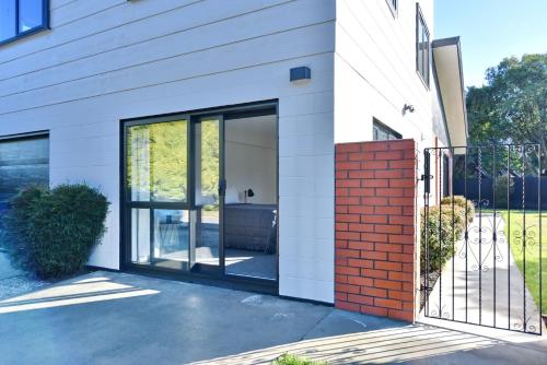 a house with sliding glass doors on it at Lavandula 3 - Christchurch Holiday Homes in Christchurch