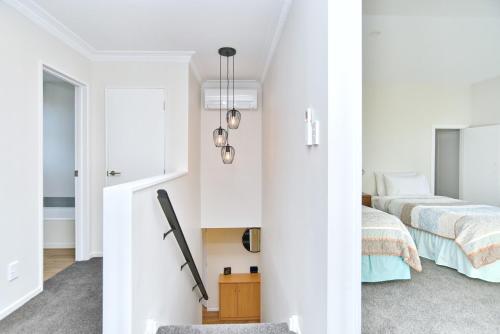 a white bedroom with a bed and a window at Lavandula 3 - Christchurch Holiday Homes in Christchurch