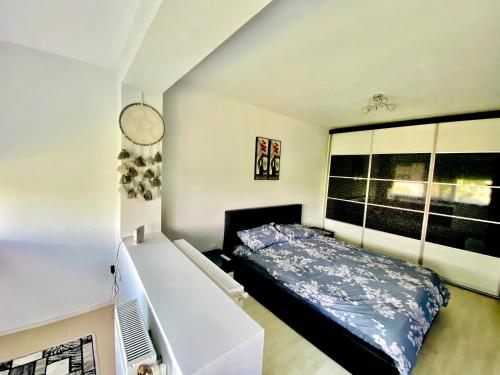 a bedroom with a bed and a large window at Cozy Central Place in Brăila