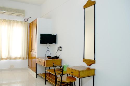 a living room with a mirror and a tv at East Coast in Trivandrum