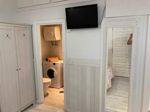 a bathroom with a toilet and a tv on the wall at 2-Estudio Zona Chamberí Quevedo in Madrid