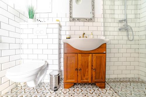 a white bathroom with a sink and a toilet at ALBERT RESIDENCE Aparthotel in Braşov
