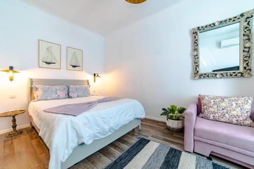 a bedroom with a bed and a mirror and a chair at ALBERT RESIDENCE Aparthotel in Braşov