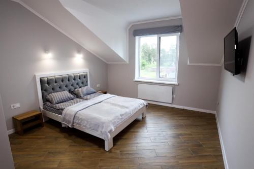 ein Schlafzimmer mit einem großen Bett und einem Fenster in der Unterkunft Apartments OCHERET in Switjas