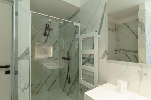 biała łazienka z prysznicem i umywalką w obiekcie B&B Nel Blu Dipinto Di Blu w mieście Polignano a Mare