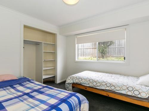 a bedroom with two beds and a window at Sunset Strip 4 in Torquay