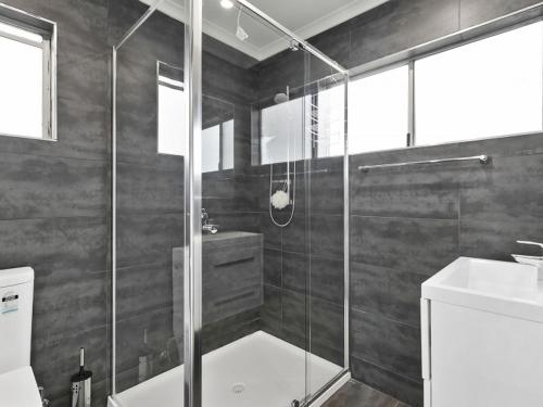 a bathroom with a shower and a toilet and a sink at Puebla Casa 17 in Torquay
