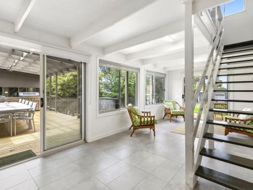 a living room with a staircase and a table and chairs at Puebla Casa 17 in Torquay