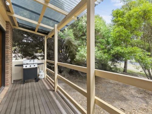 a patio with a grill on a wooden deck at Muirfield Beach Unit 1-23 in Torquay