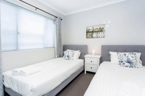2 camas en un dormitorio con ventana en Parkland View Sanctuary - EXECUTIVE ESCAPES en Perth