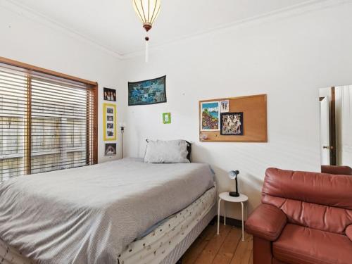 een slaapkamer met een bed en een bank bij Munday Street Prime 17 in Torquay