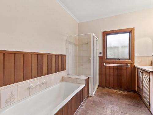 een grote badkamer met een bad en een raam bij Munday Street Prime 17 in Torquay