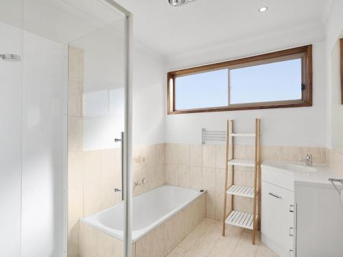 La salle de bains est pourvue d'une baignoire et d'un lavabo. dans l'établissement Holyhead On Whites Beach 11, à Torquay